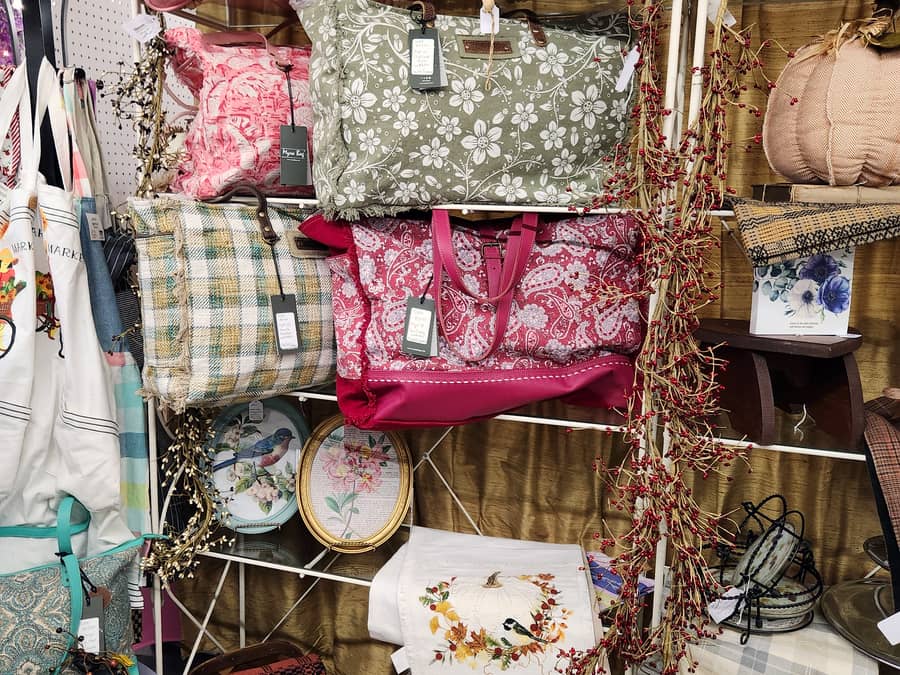Quilted bags, cushions and floral textiles on a vendor stand