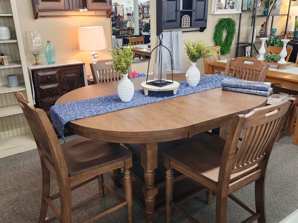 An oval extension dining table in warm oak with spindle back chairs
