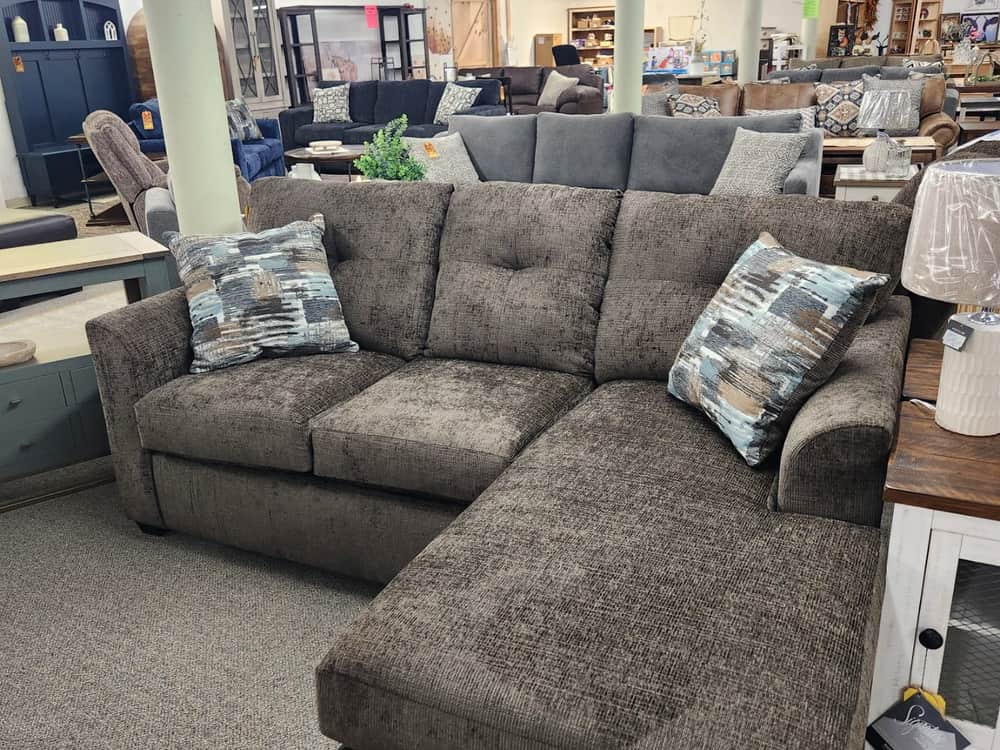 A taupe chenille chaise sectional with patterned cushions