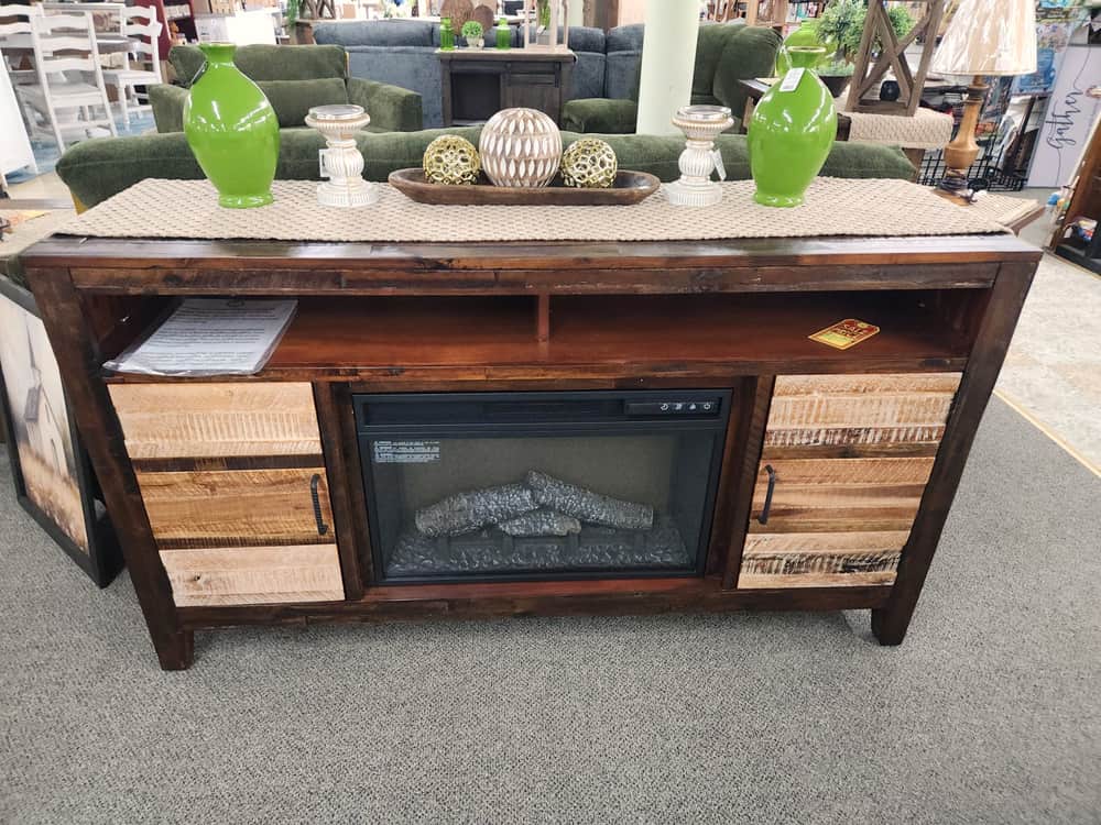 A rustic wood media console with a built in electric fireplace