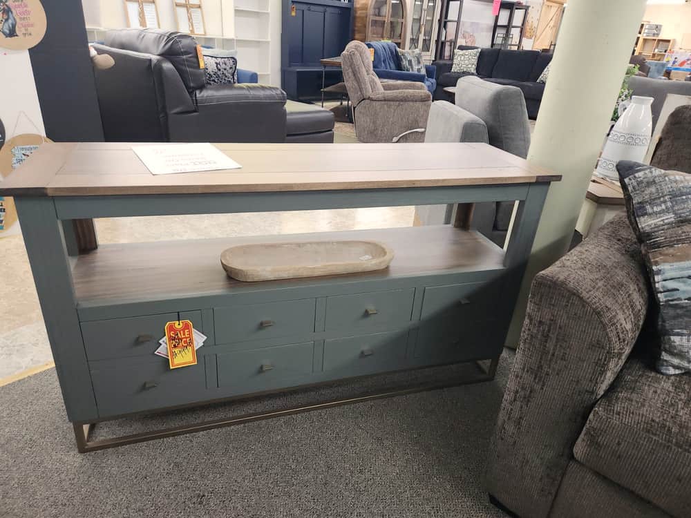 A teal console table with a wood top and a lower shelf