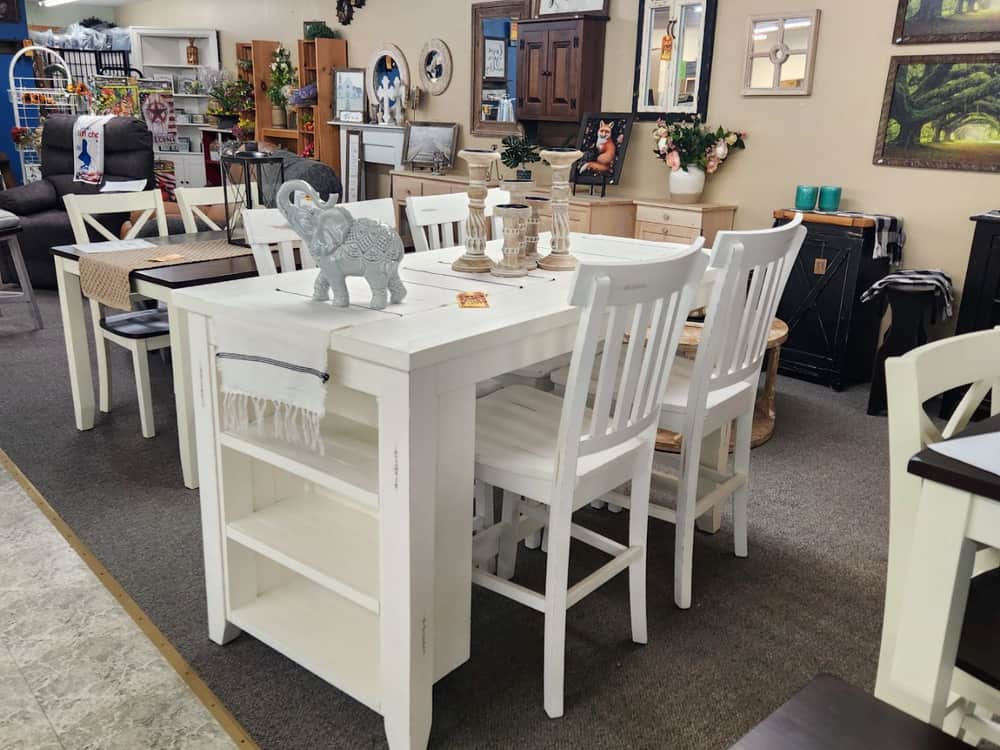 A white counter height dining set with matching white chairs
