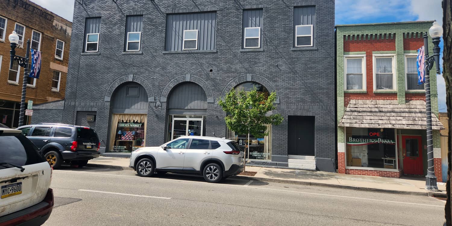 The grey brick front of the Thieves Market building on Front Street in Philipsburg