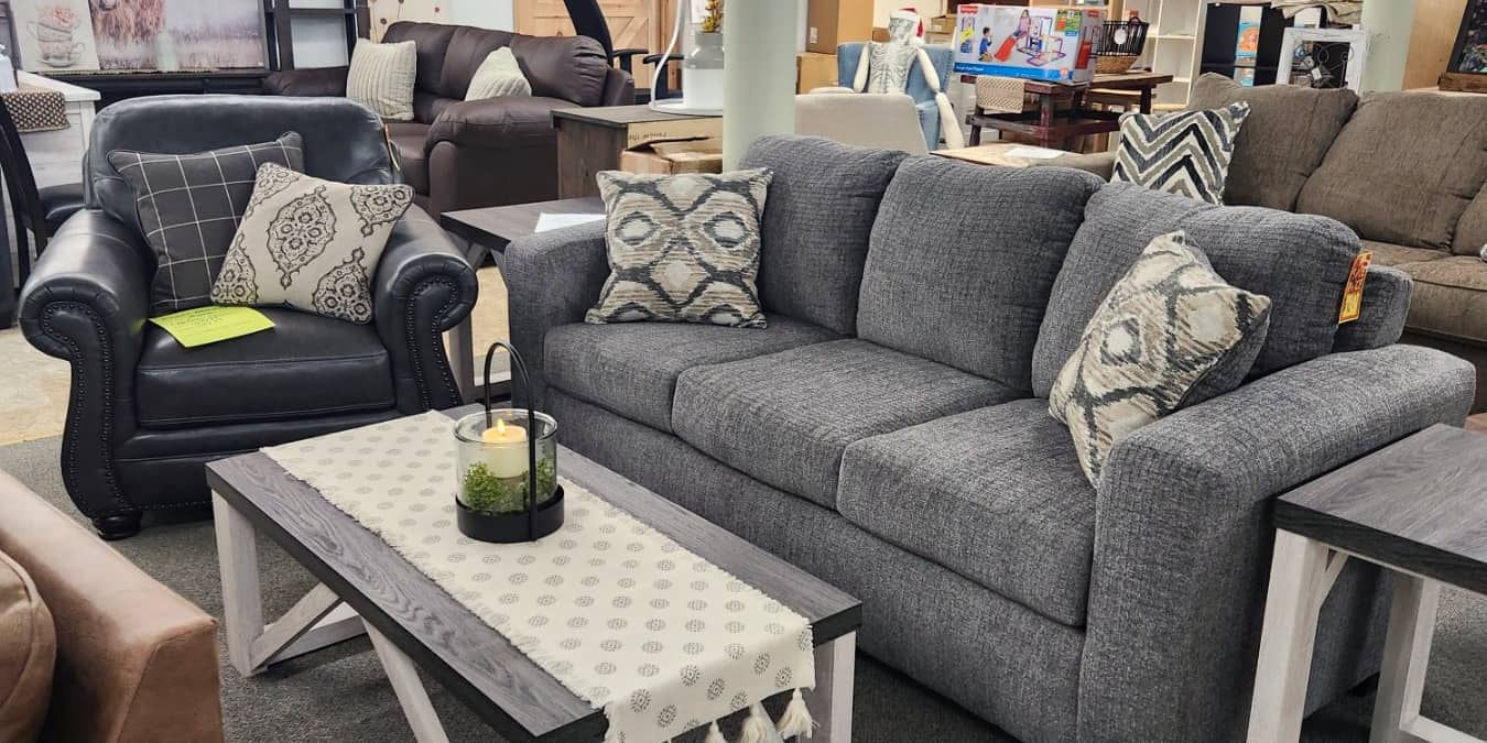 A grey sofa with a white and wood coffee table on the first floor at Thieves Market