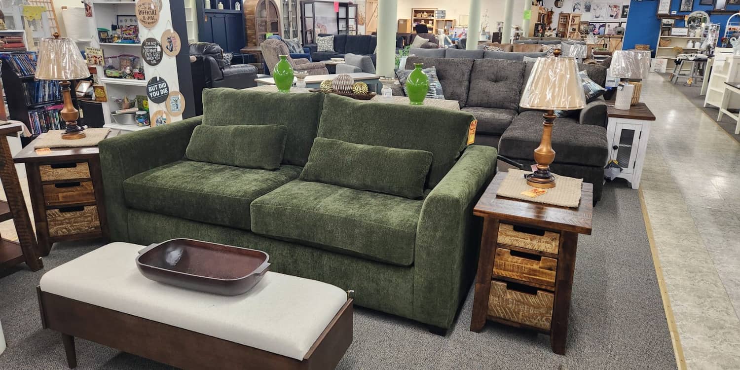 An olive green sofa with a cream bench on the first floor at Thieves Market