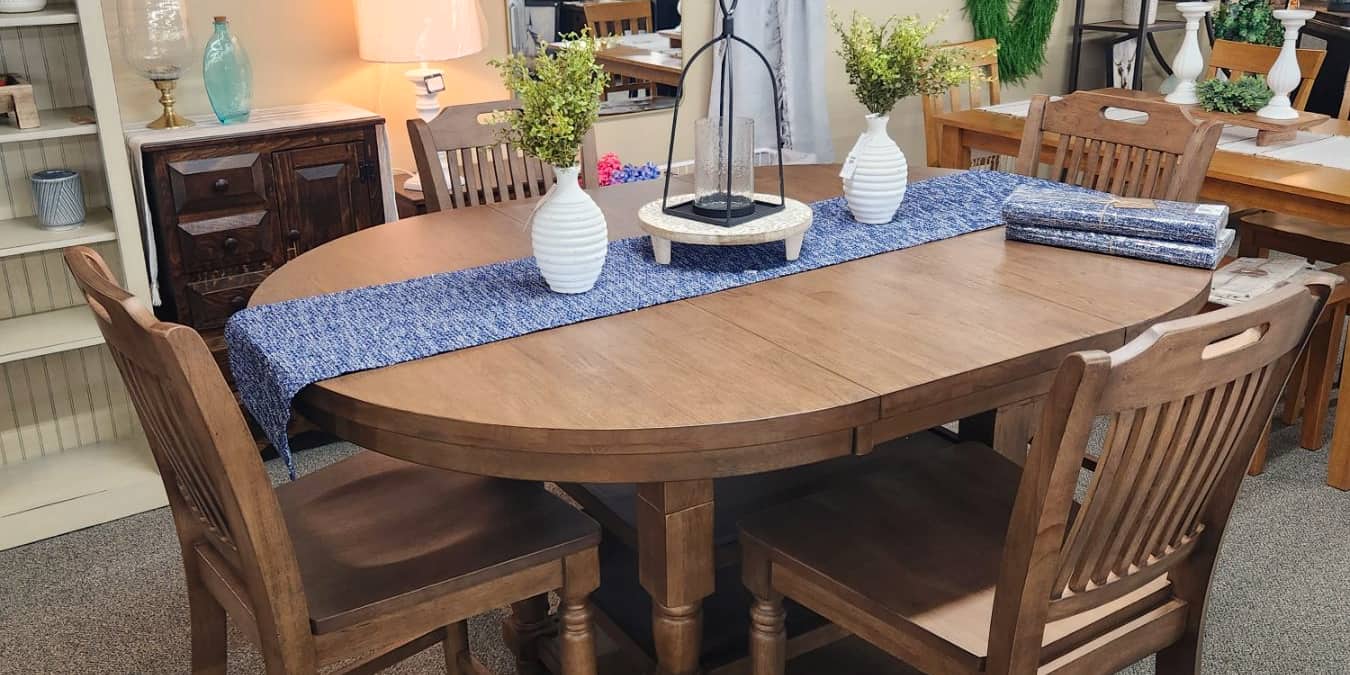 An oval oak extension dining table with spindle back chairs at Thieves Market