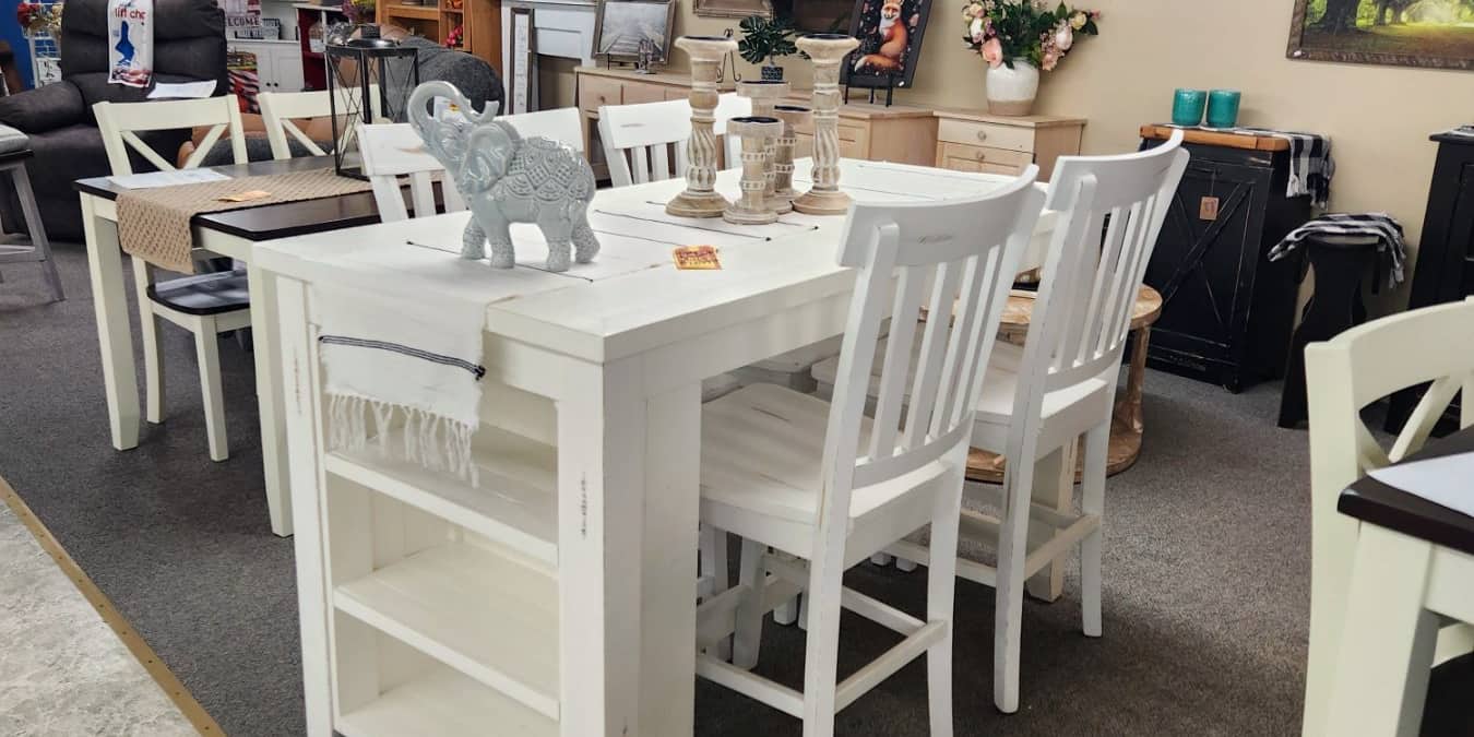 A white counter height dining set with matching stools on the first floor at Thieves Market