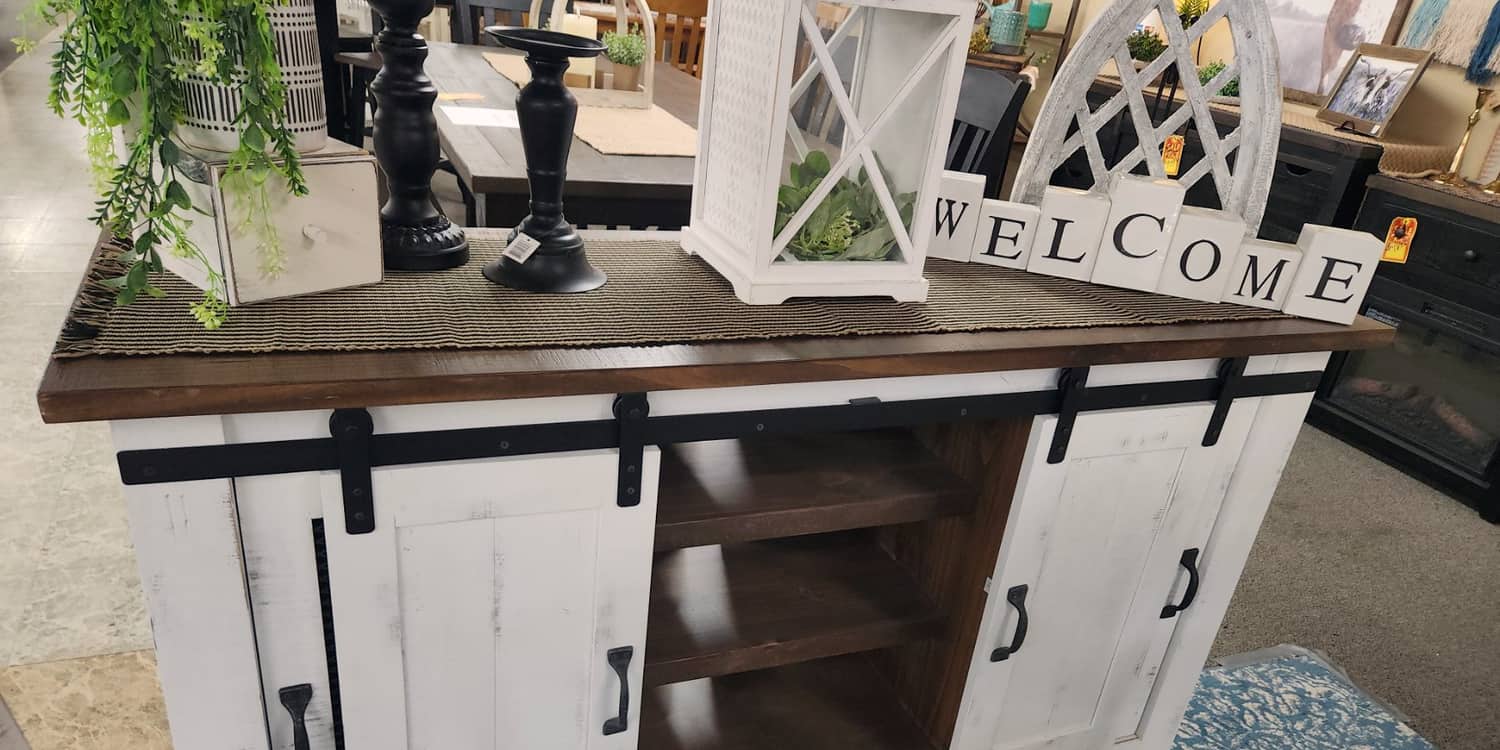 A distressed white media console with sliding barn doors at Thieves Market
