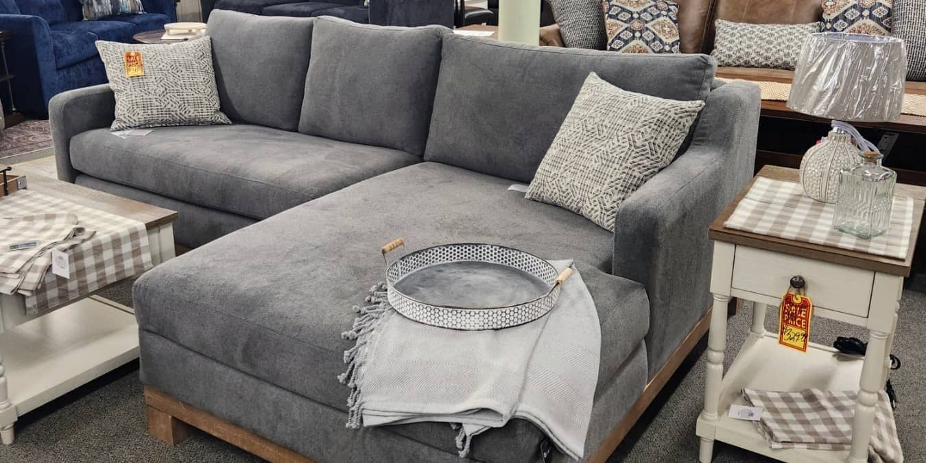 A grey chaise sectional on a wood base on the first floor at Thieves Market