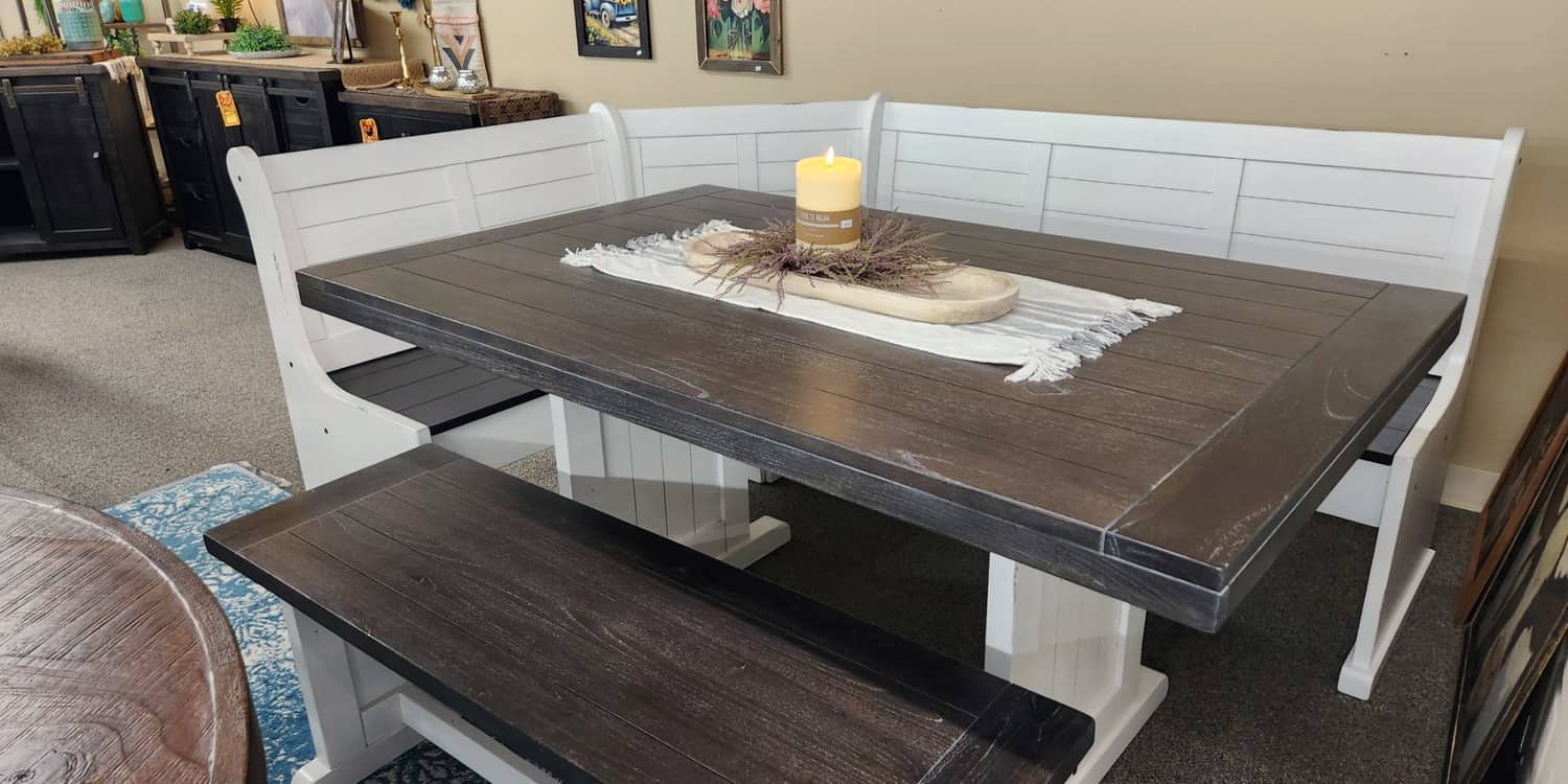 A white corner breakfast nook with a dark wood table and bench on the first floor at Thieves Market
