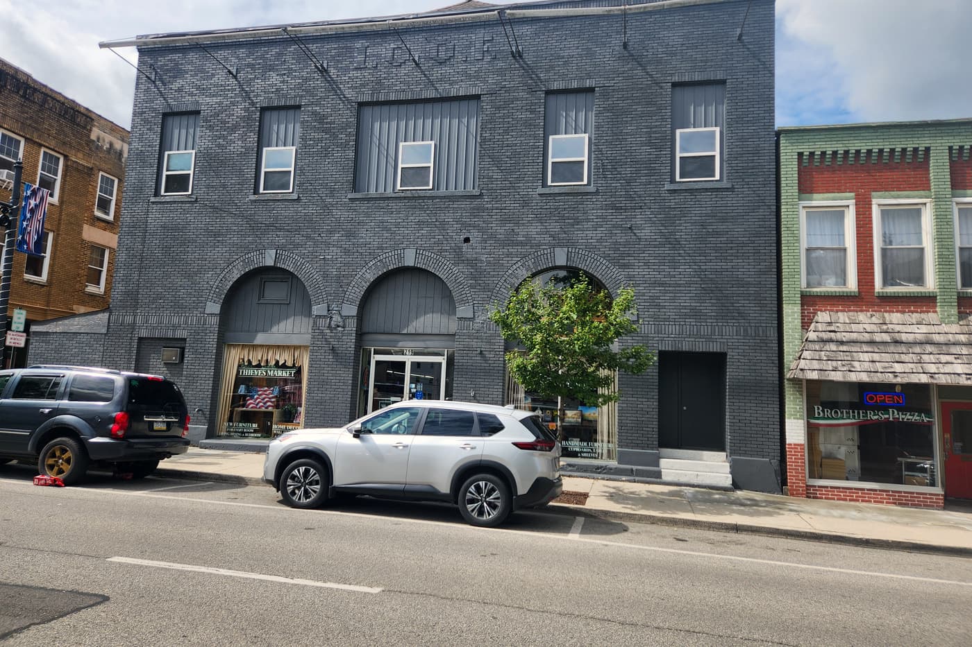 The grey brick front of Thieves Market at 219 N Front Street in Philipsburg, with arched windows and the shop name in the glass