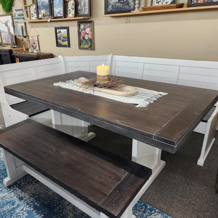 A white corner breakfast nook with bench seating and a dark wood top, on the Thieves Market first floor