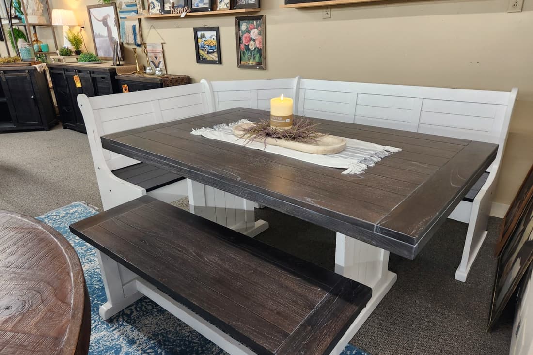 A white corner breakfast nook with bench seating and a dark wood top at Thieves Market