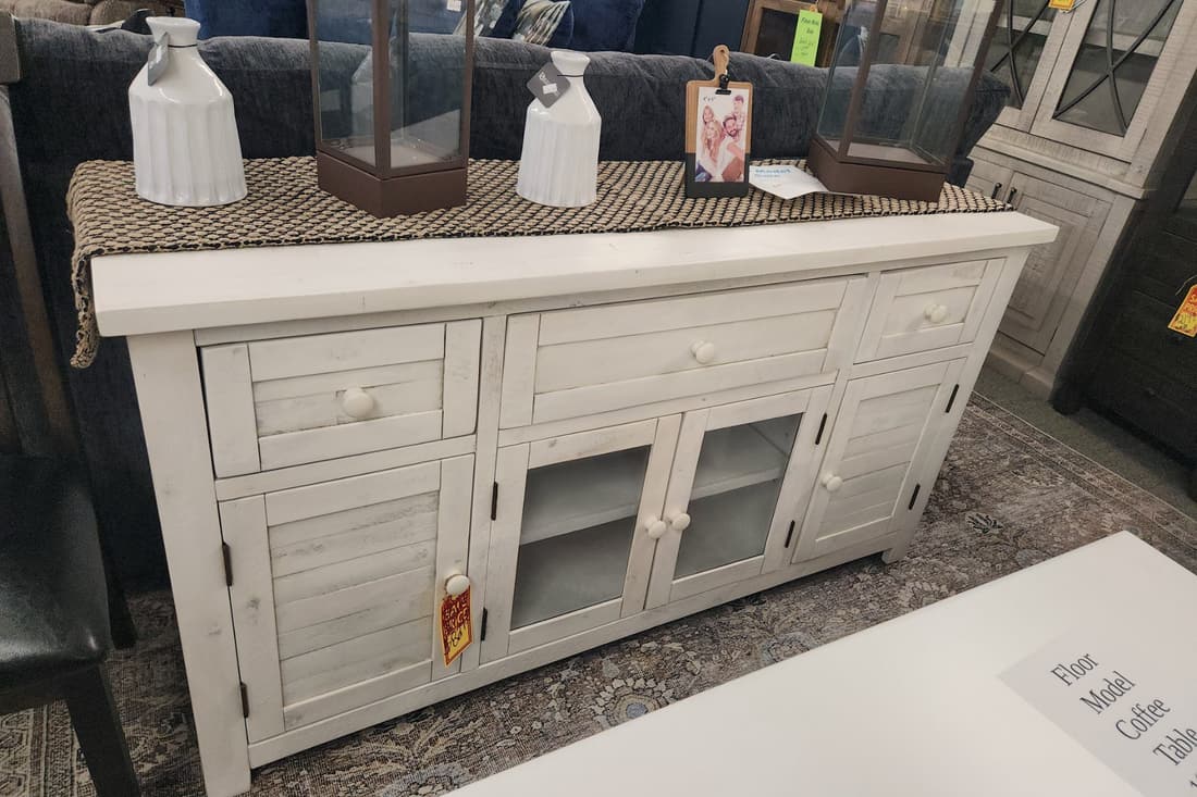 A distressed white sideboard with glass cabinet doors on the Thieves Market first floor