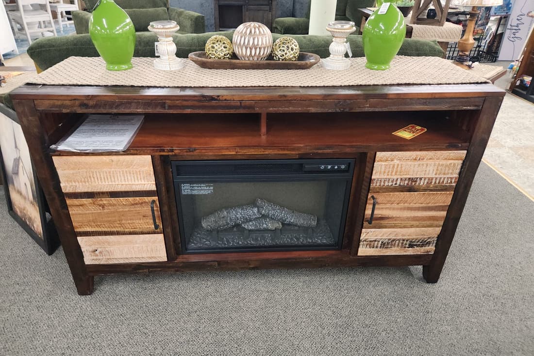 A rustic wood media console with a built in electric fireplace at Thieves Market